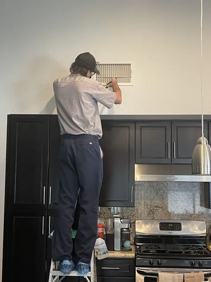 Technician inspecting an air vent during HVAC service in Harrisonburg